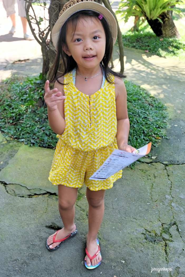 Anya nampak seperti Dora yang siap explore Bali Bird Park dengan peta di tangannya